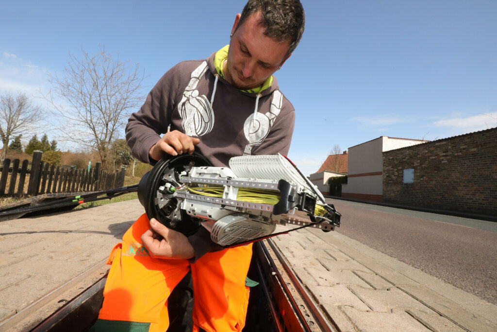 Eine Person, die gerade Glasfaser verlegt