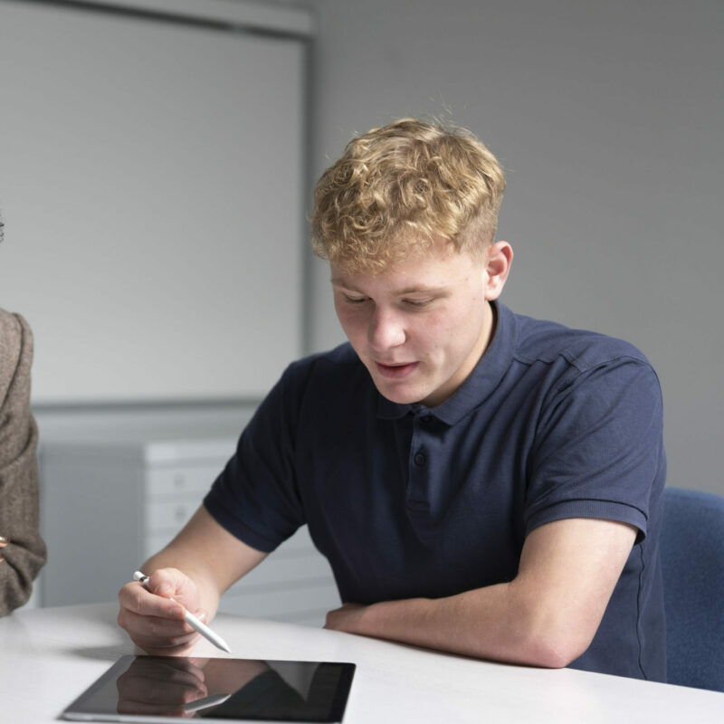 Ein Auszubildender bedient sein Tablet.