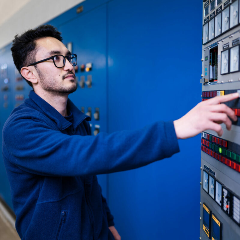 Ein Mitarbeiter arbeitet an einem Technikschrank.